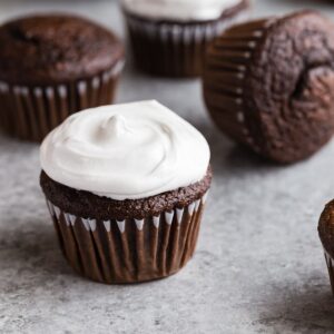 Side view of Old-fashioned 7 Minute Frosting swirled on top of chocolate cupcakes.