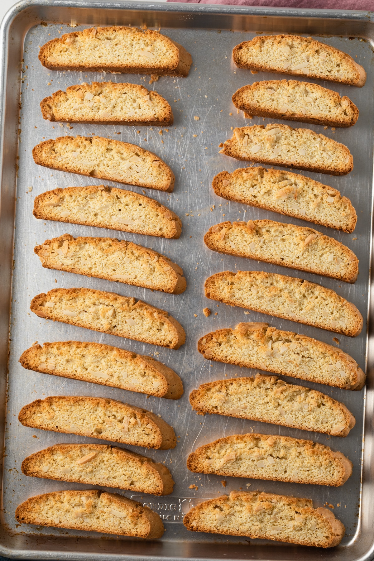 Baked almond biscotti on baking sheet.