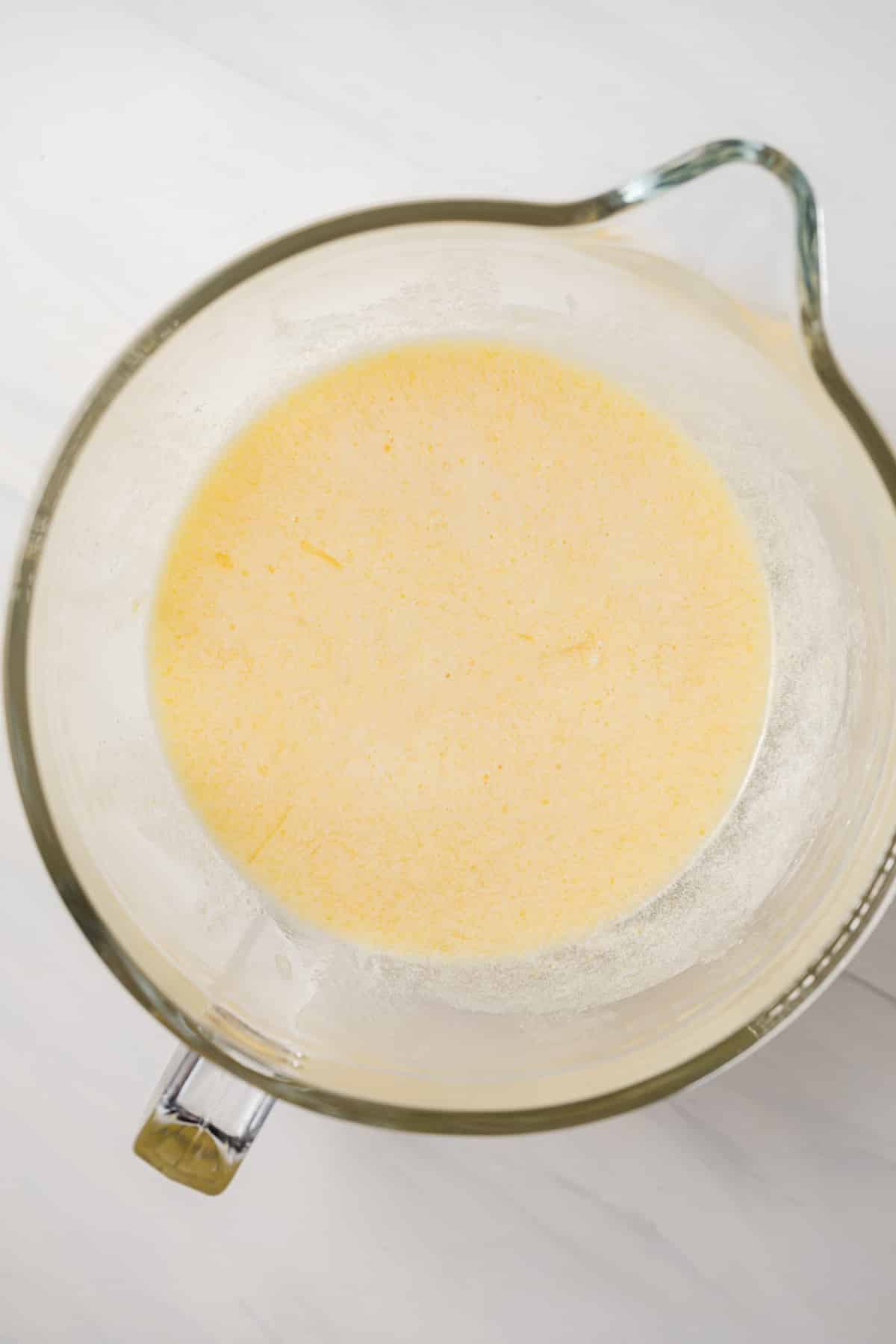 Wet ingredients mixed in glass bowl.