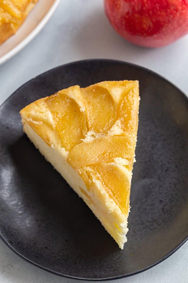high angled view of a slice of apple cake on a dark blue plate