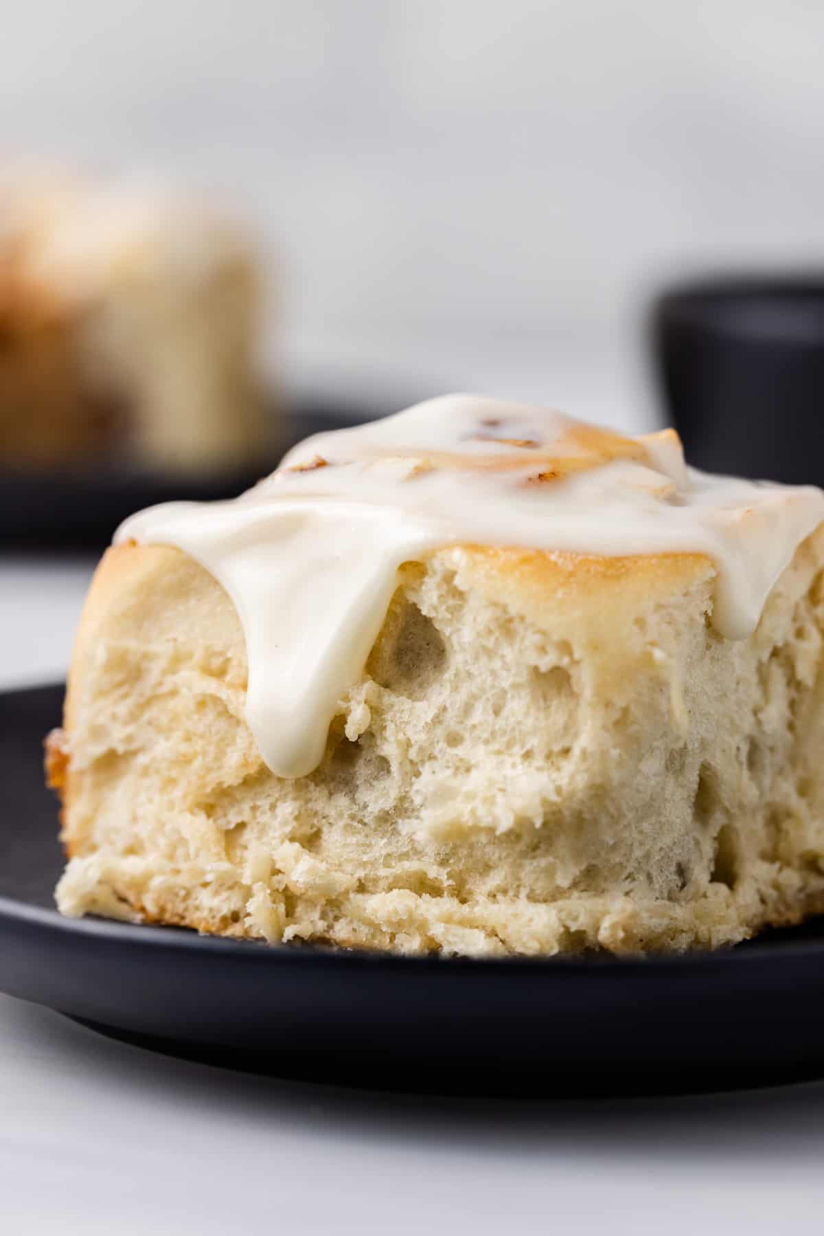Side view of a glazed apple cinnamon roll on a plate