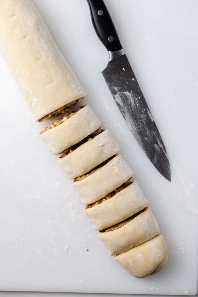 An unbaked apple cinnamon roll cut into slices