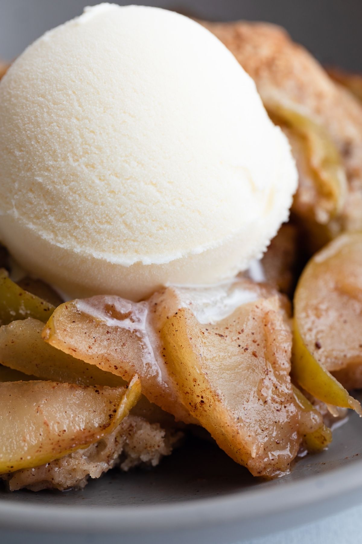 overhead view of apple cobbler and vanilla ice cream in a bowl