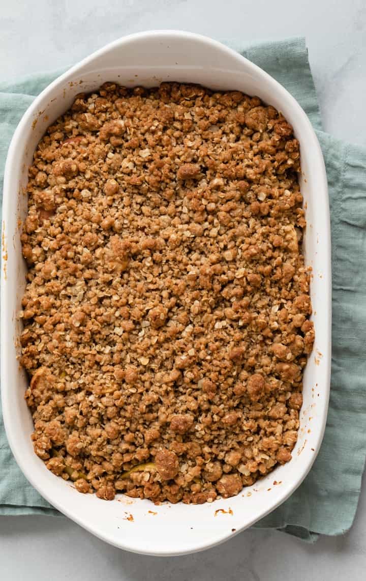 overhead of baked apple crisp in a white casserole dish