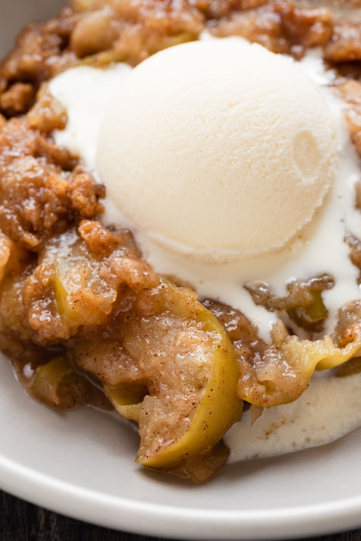 apple crumble in a bowl with ice cream scooped on top