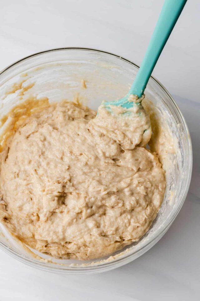 A blue spoon stirring muffin batter