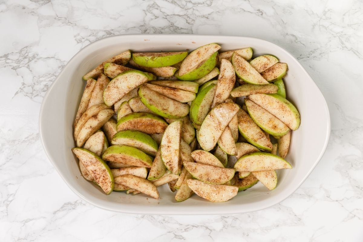 overhead view of apple slices in a white casserole dish