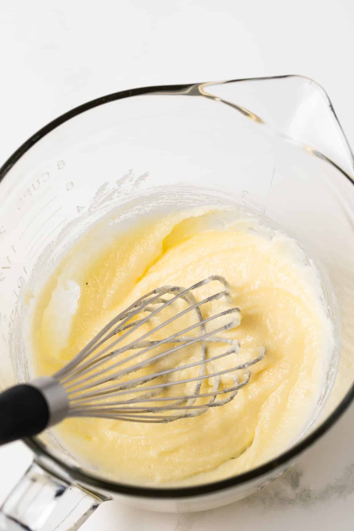 Butter and sugar mixed in glass bowl.