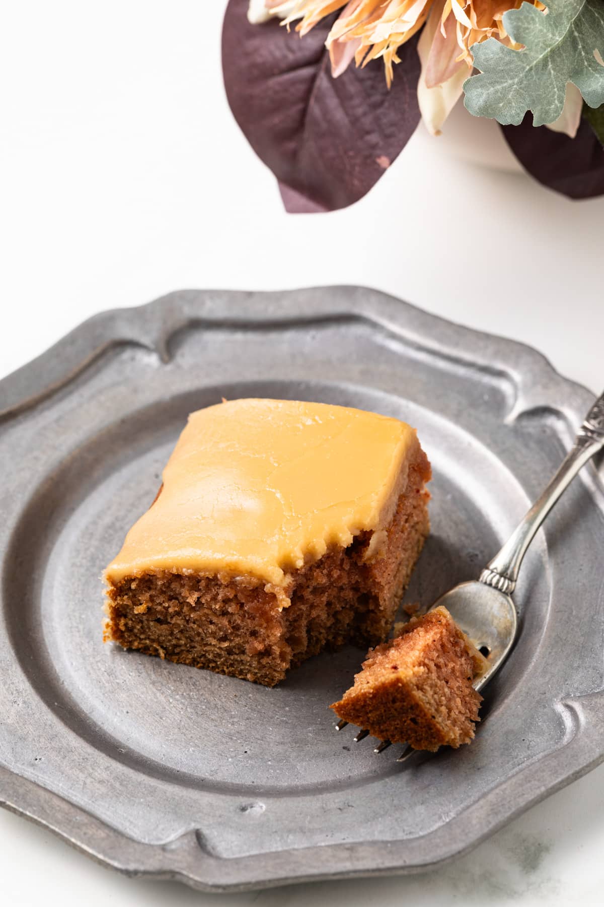 Bite taken out of slice of applesauce cake.