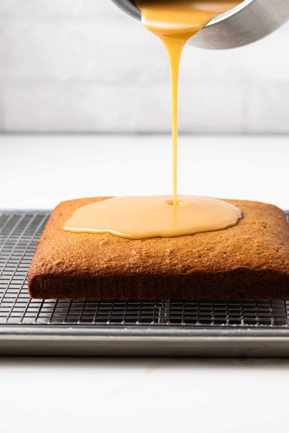 Glaze poured over applesauce cake.
