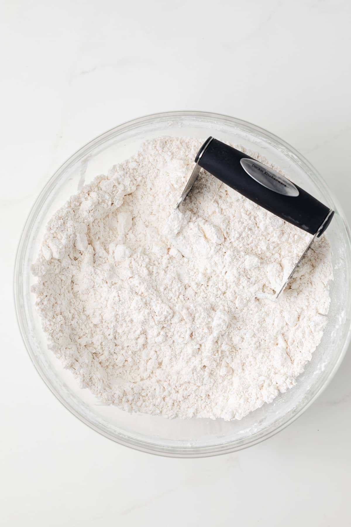 Butter cut into flour in glass bowl.