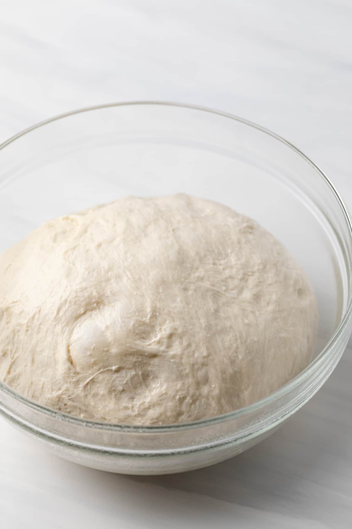proofed baguette dough in glass bowl