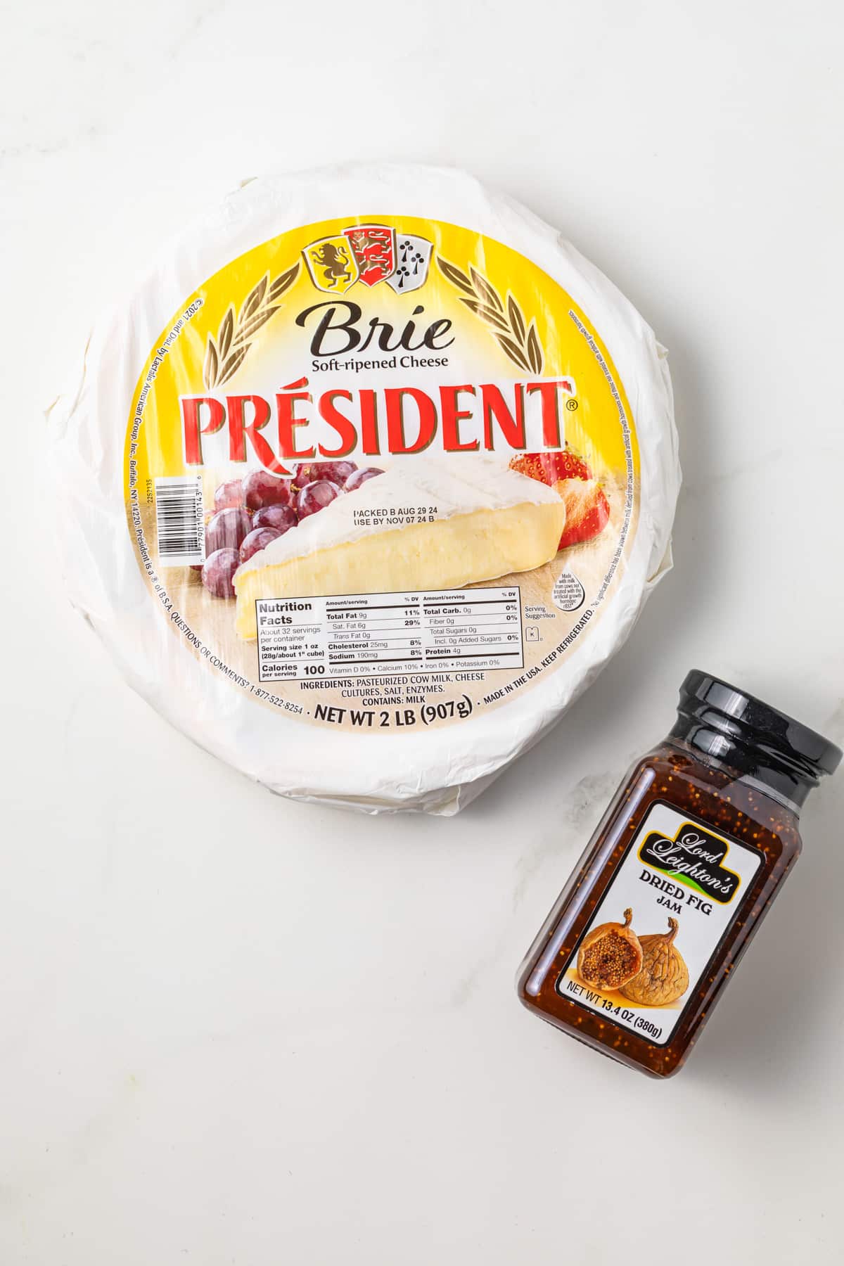 Wheel of brie and jar of fig jam.