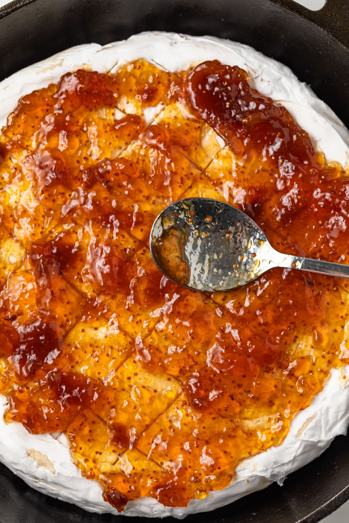 Fig jam spread over brie in skillet.