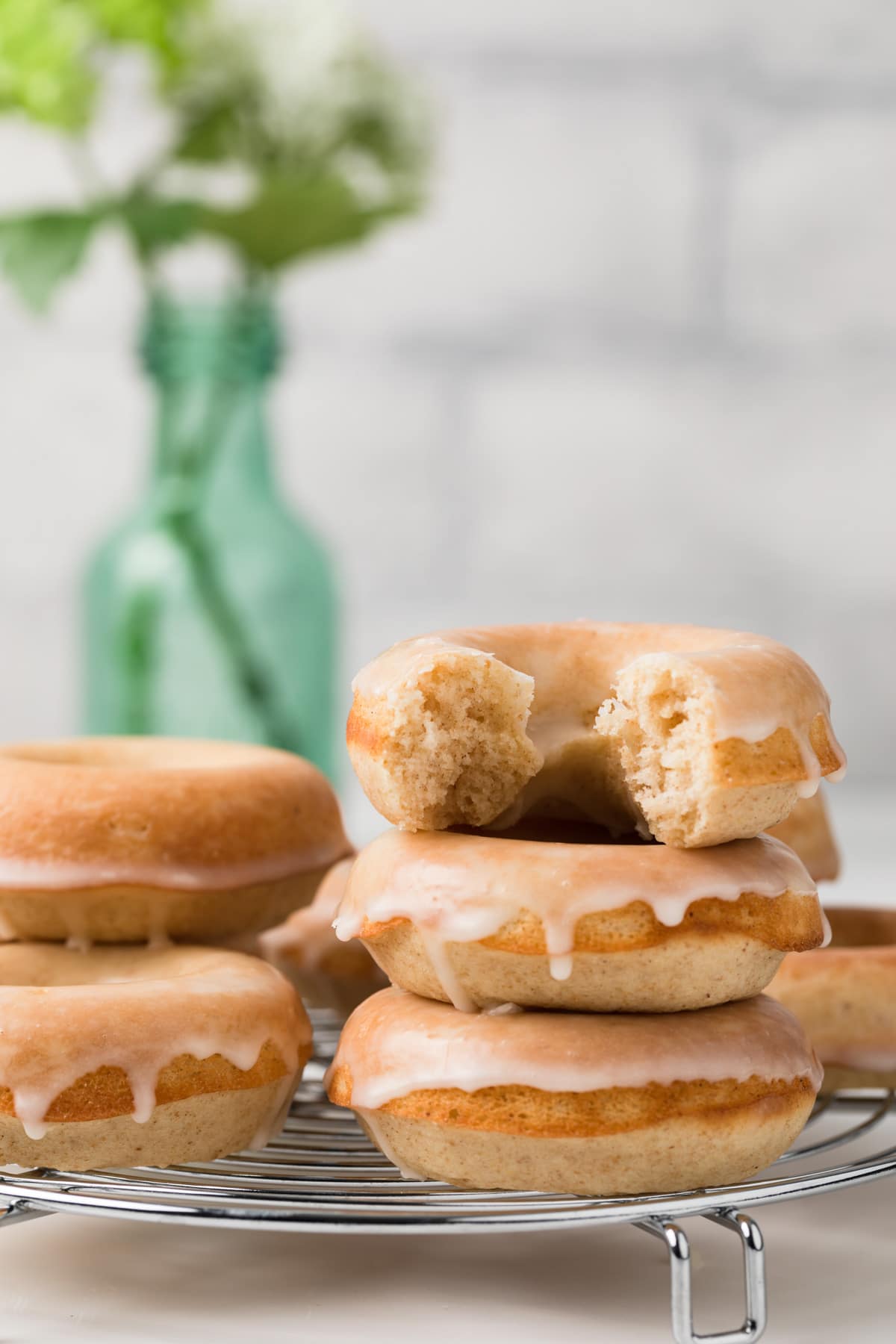 baked donuts stacked three high with a bite taken out of the top donut