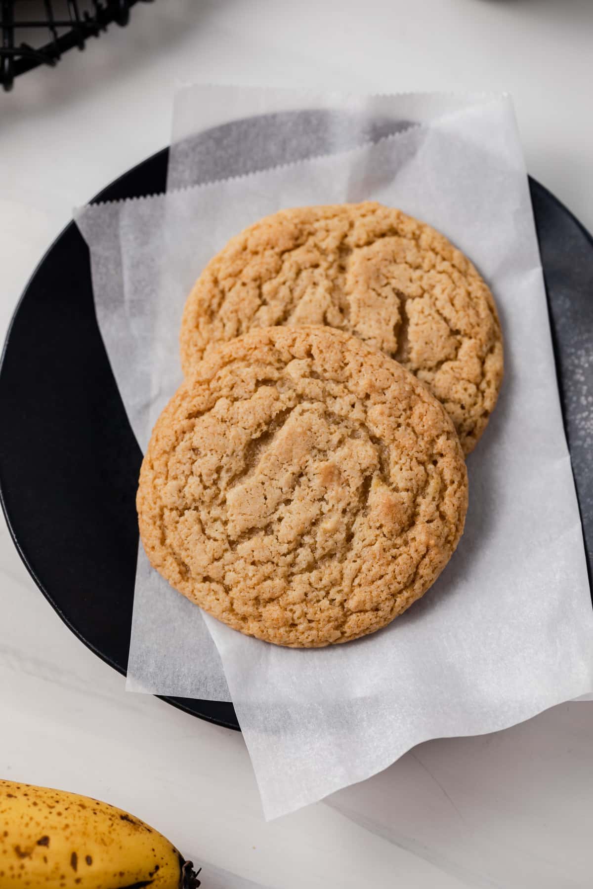 Two banana cookies on a plate.