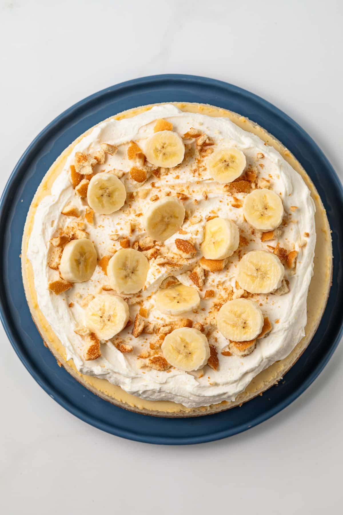 Banana pudding cheesecake on blue serving plate.