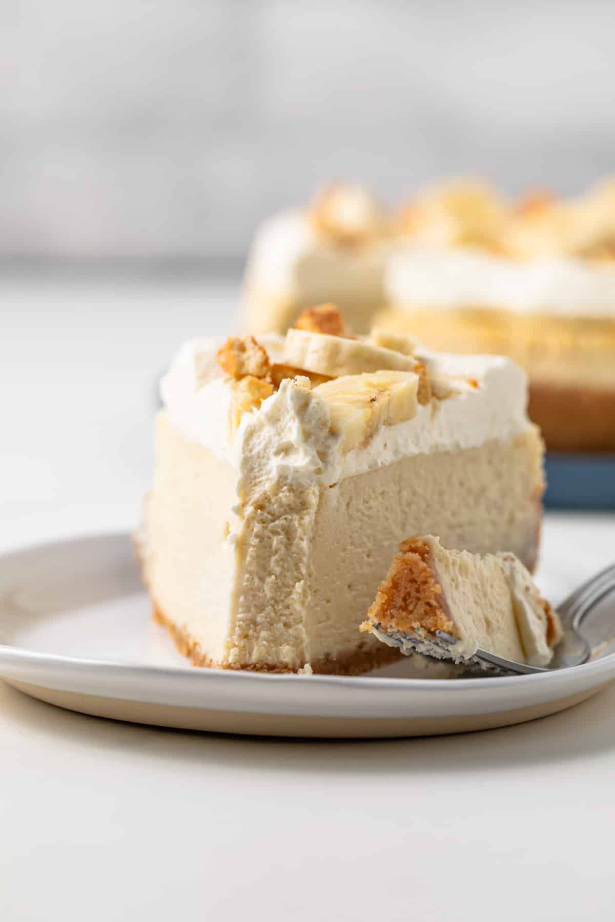 Slice of banana pudding cheesecake with a fork.