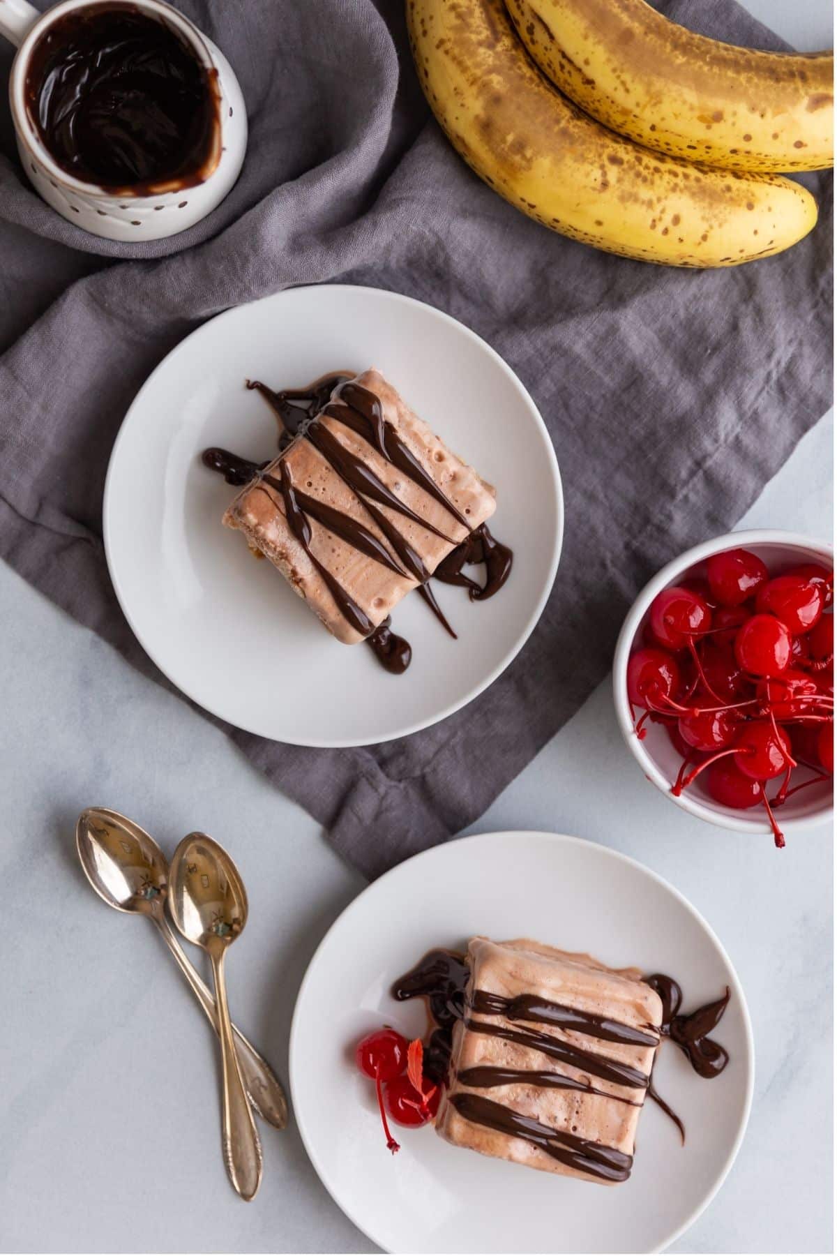 Overhead view of slices of banana split icebox cake on plates.