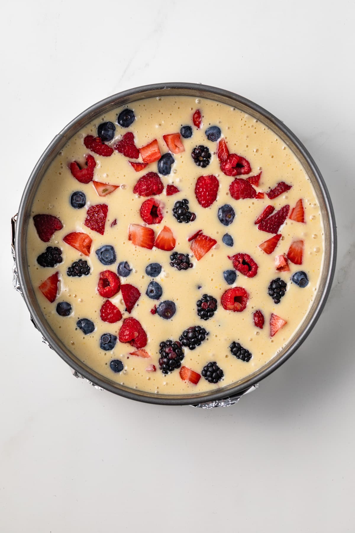Unbaked berry cake in round pan.