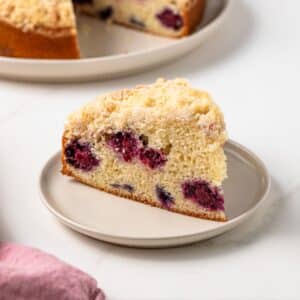 Slice of berry crumb cake on plate.