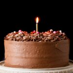 Classic Birthday Cake on a marble cake stand with a wooden base
