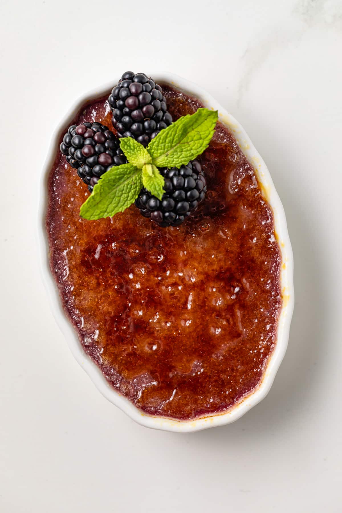 Single ramekin of blackberry creme brulee.