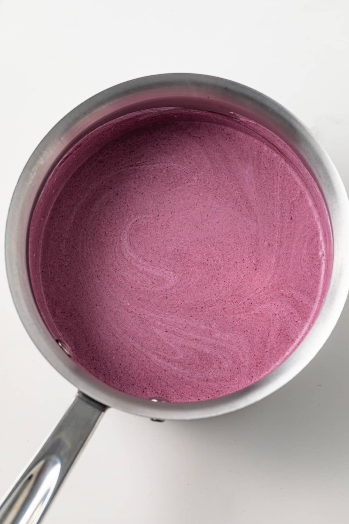 Blackberry puree and heavy cream in saucepan.