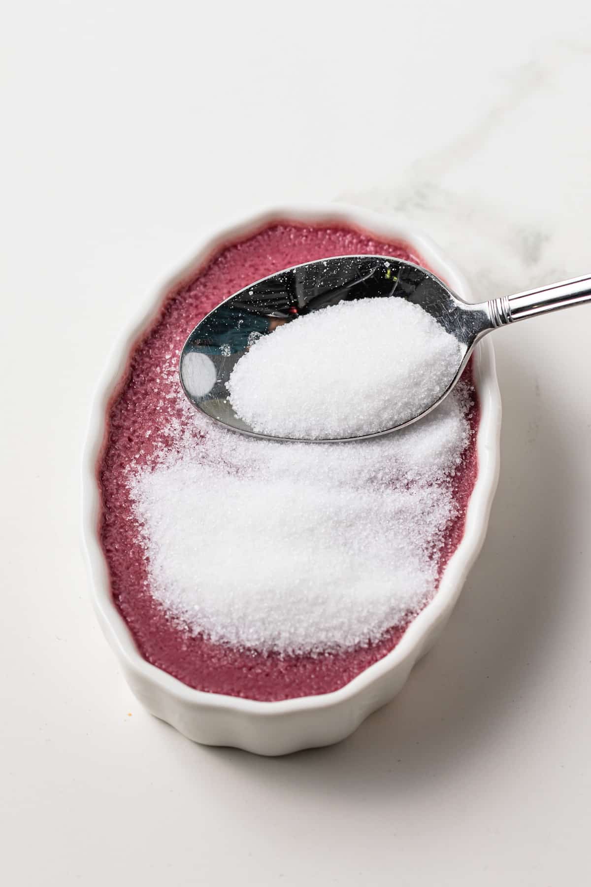 Spooning sugar over blackberry creme brulee.