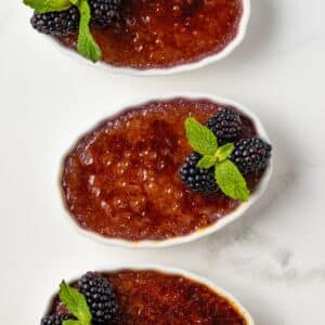 Three ramekins of blackberry creme brulee.