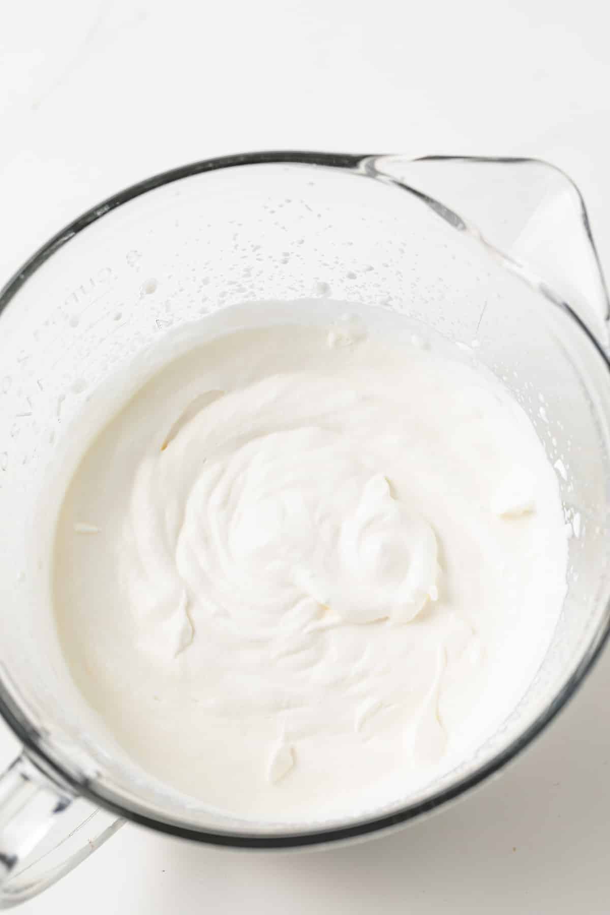Whipped cream in glass bowl.