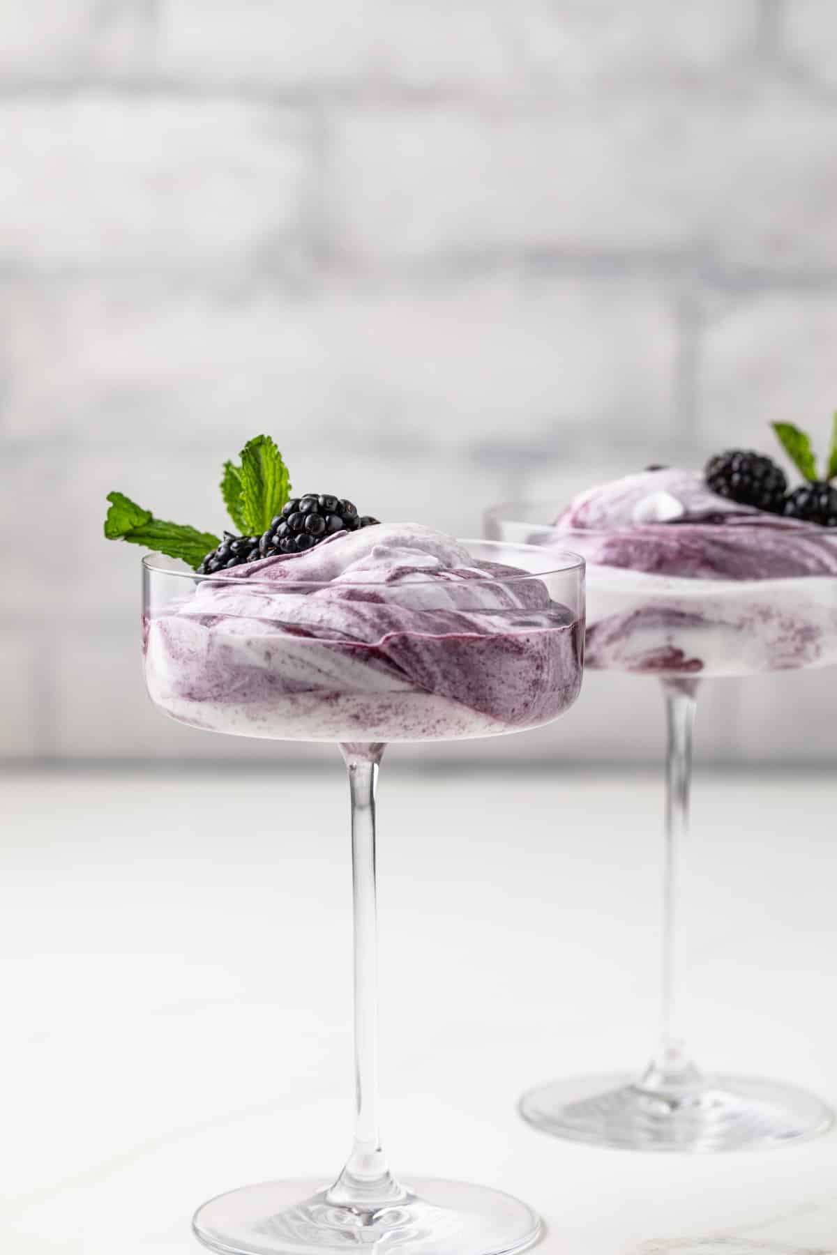 Side view of blackberry fool in glass cup.