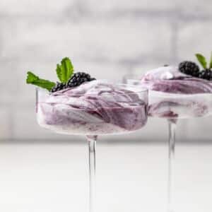 Side view of blackberry fool in glass cup.