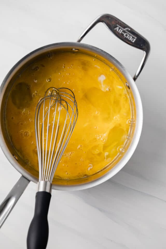 Eggs whisked in saucepan.