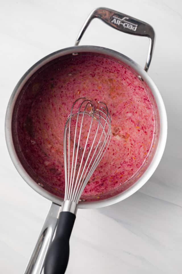Eggs with blood orange juice whisked in sauce pan.