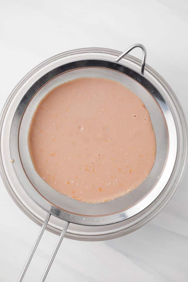 Filling being strained through fine mesh sieve.