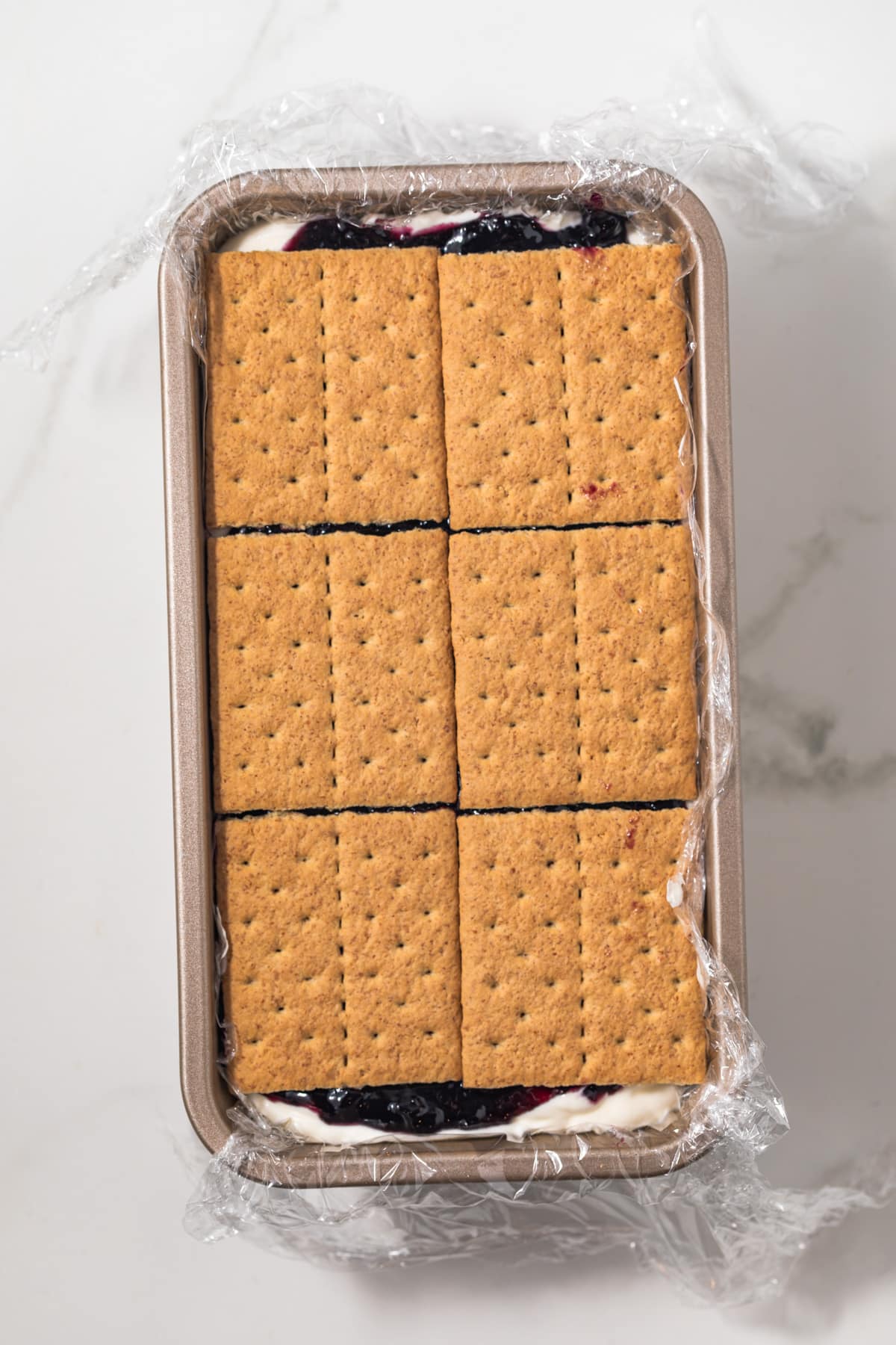 Graham crackers topping icebox cake in pan.