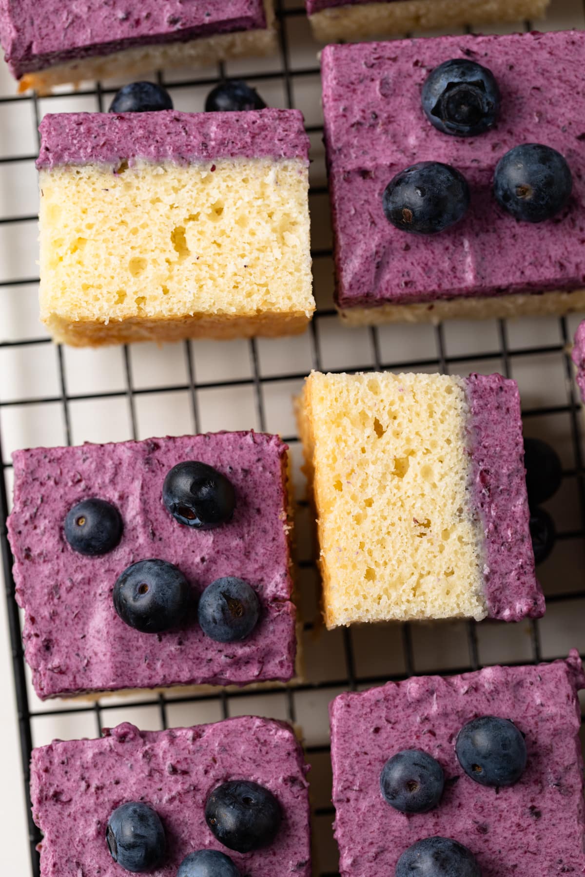 Slices of blueberry mousse cake on wire rack.