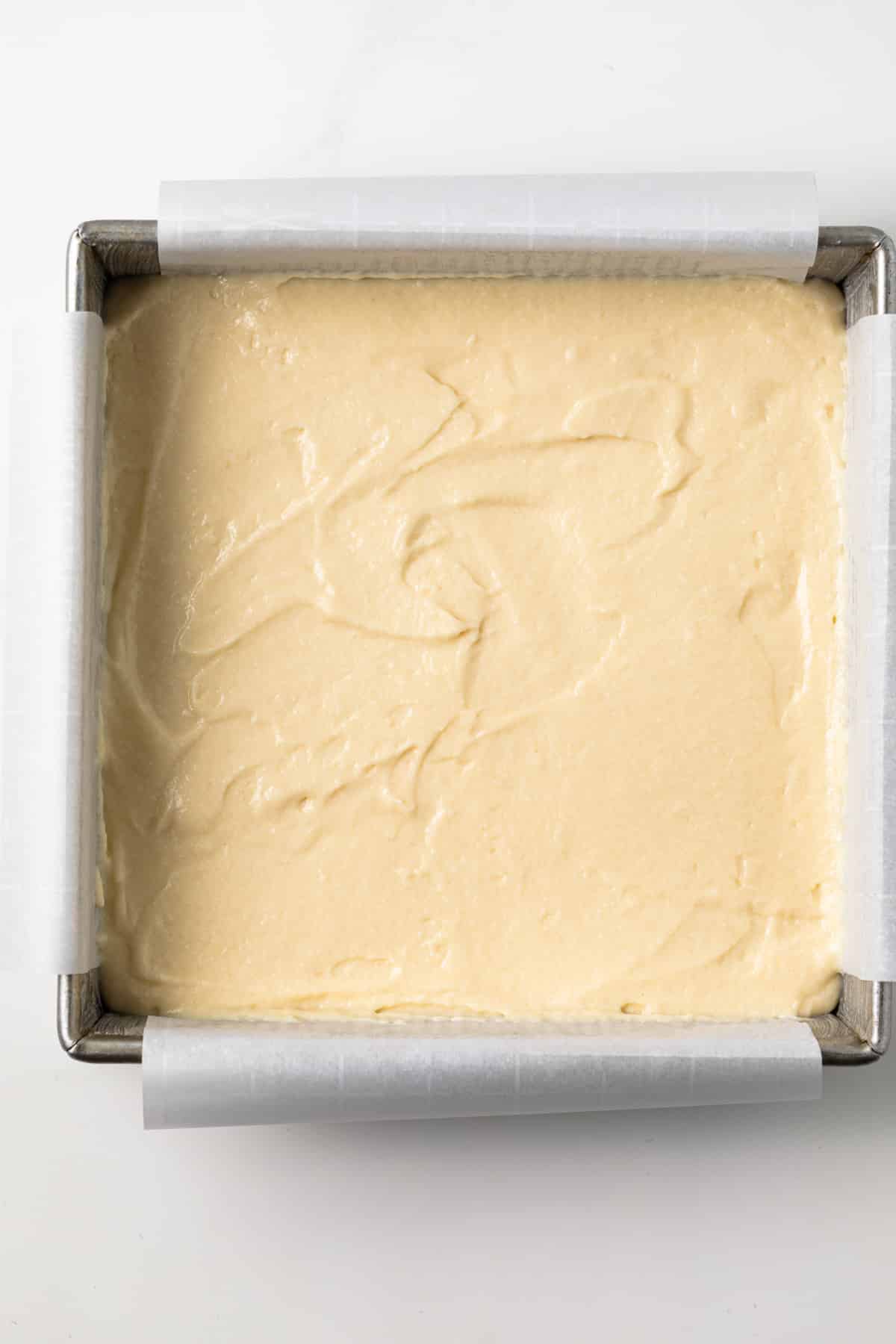 Unbaked cake batter in square pan.