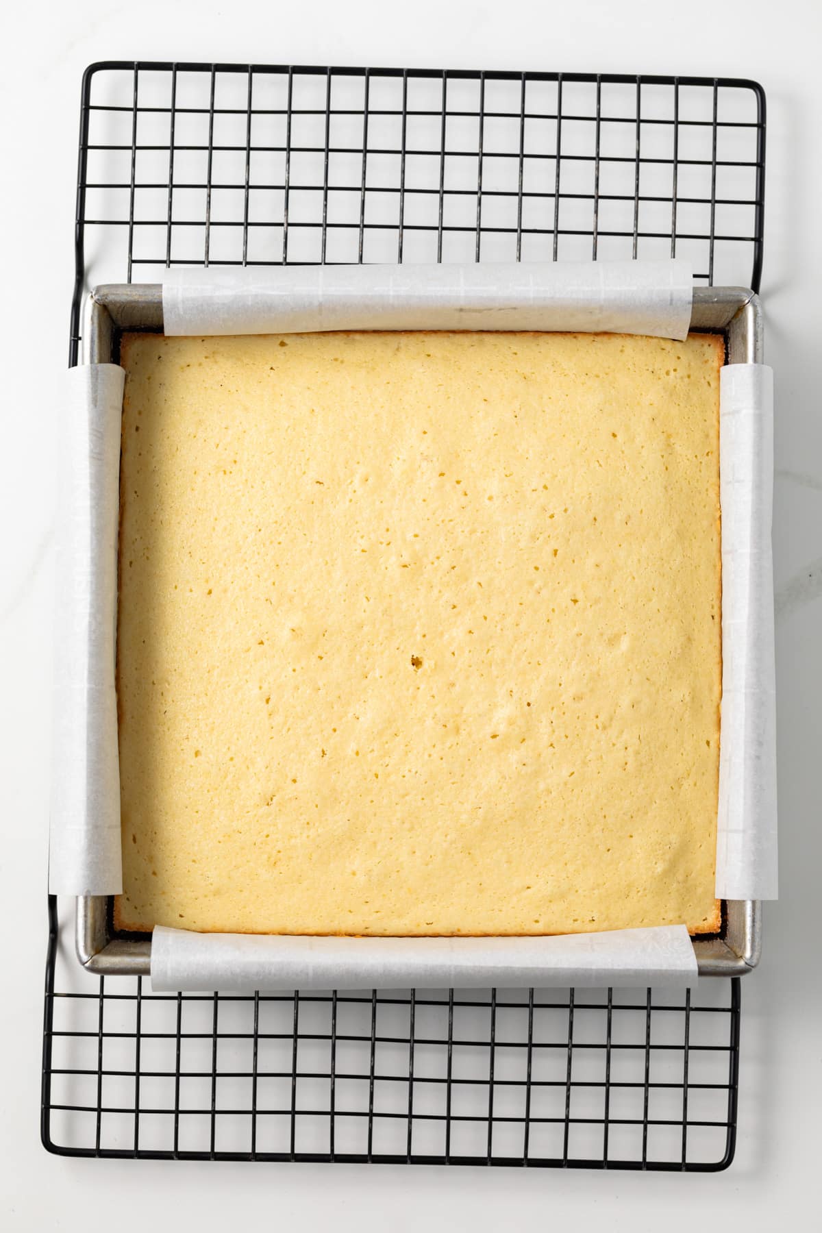 Baked yellow cake in square pan.