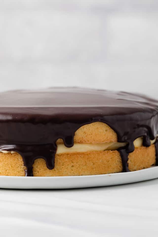 Close up of boston cream pie on white plate.