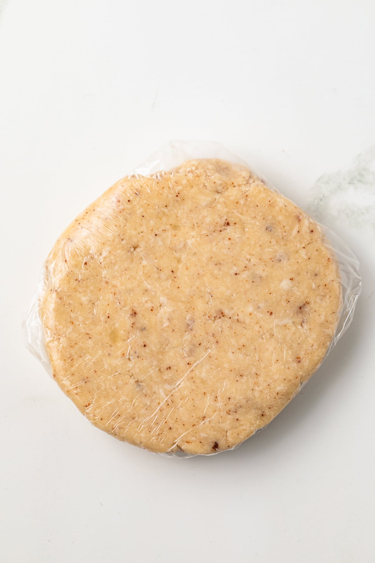 Brown butter pie crust wrapped in plastic wrap.