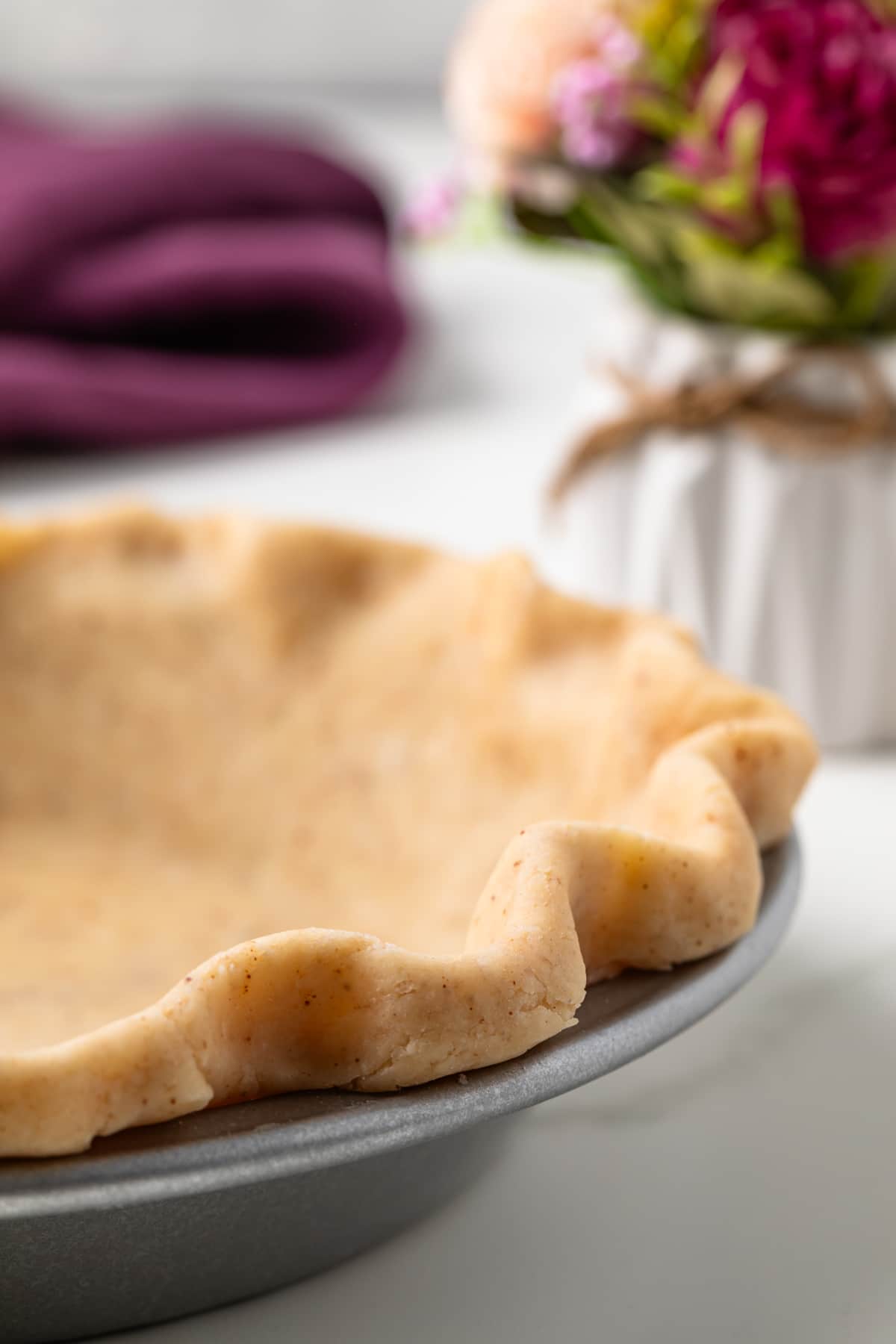 Side view of brown butter crust in pie plate.