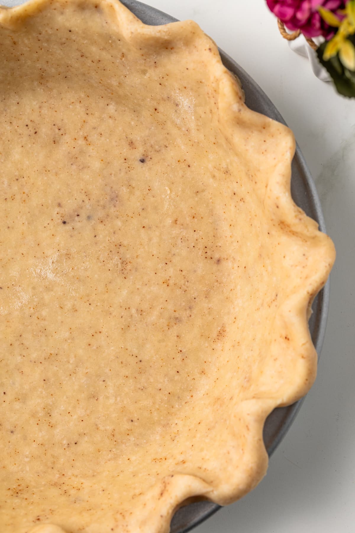 Close up of brown butter pie crust in pie plate.