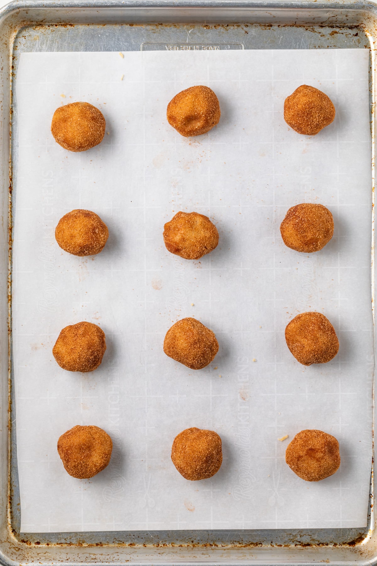 Raw cookie dough balls on baking pan.
