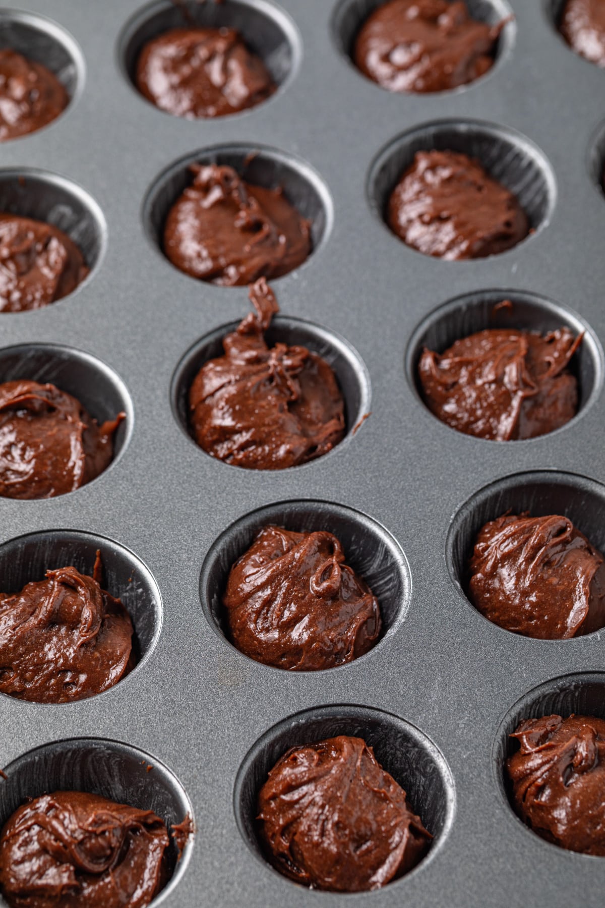 Brownie batter in mini muffin pan.