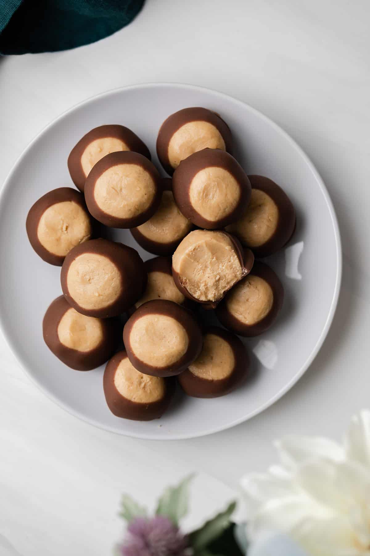 overhead of buckeye candy on a white plate with a bite taken out of one