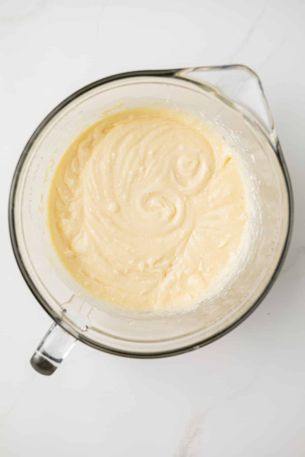 Eggs, butter, flour mixed together in glass bowl.
