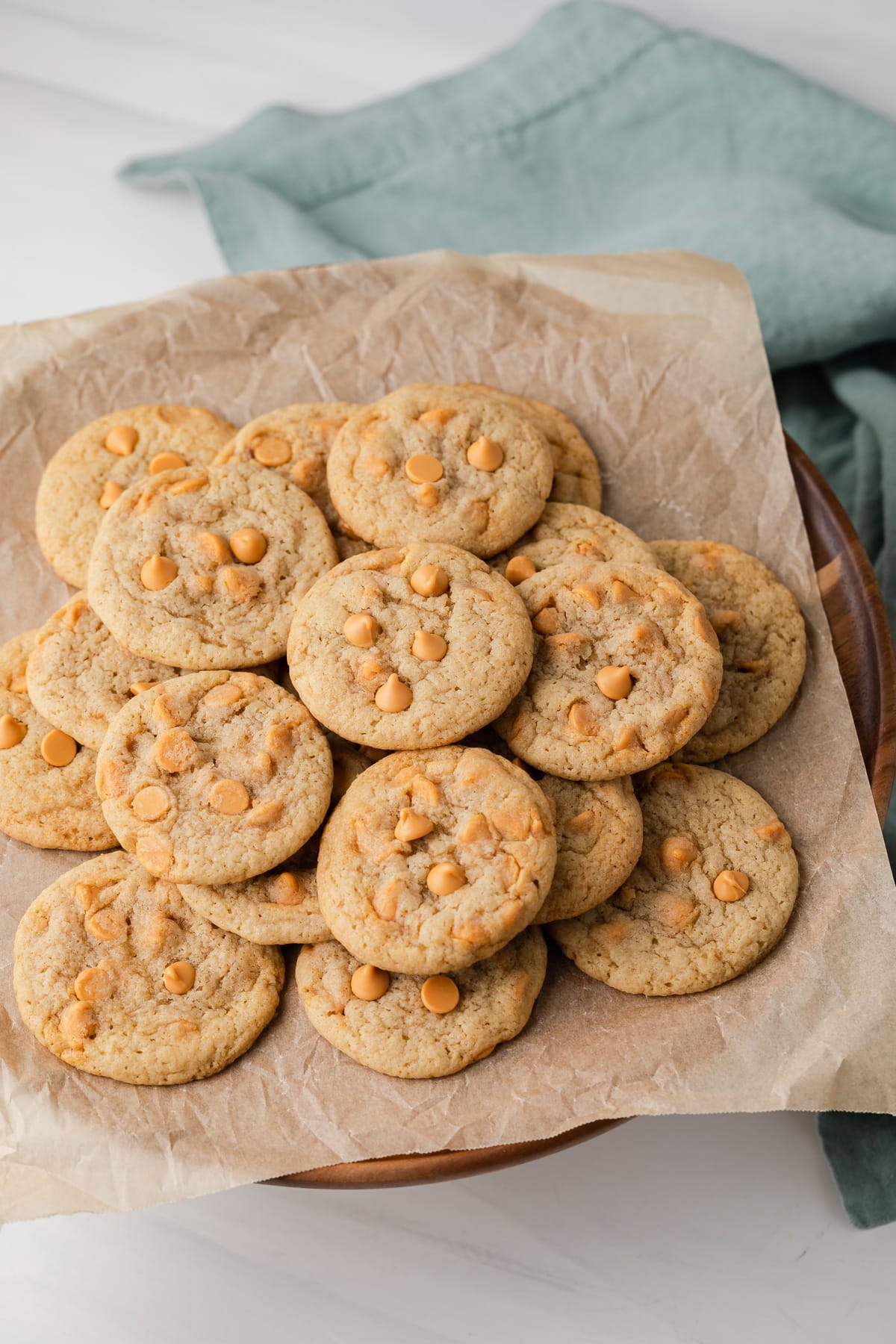 Butterscotch cookies on a wooden cake stand.