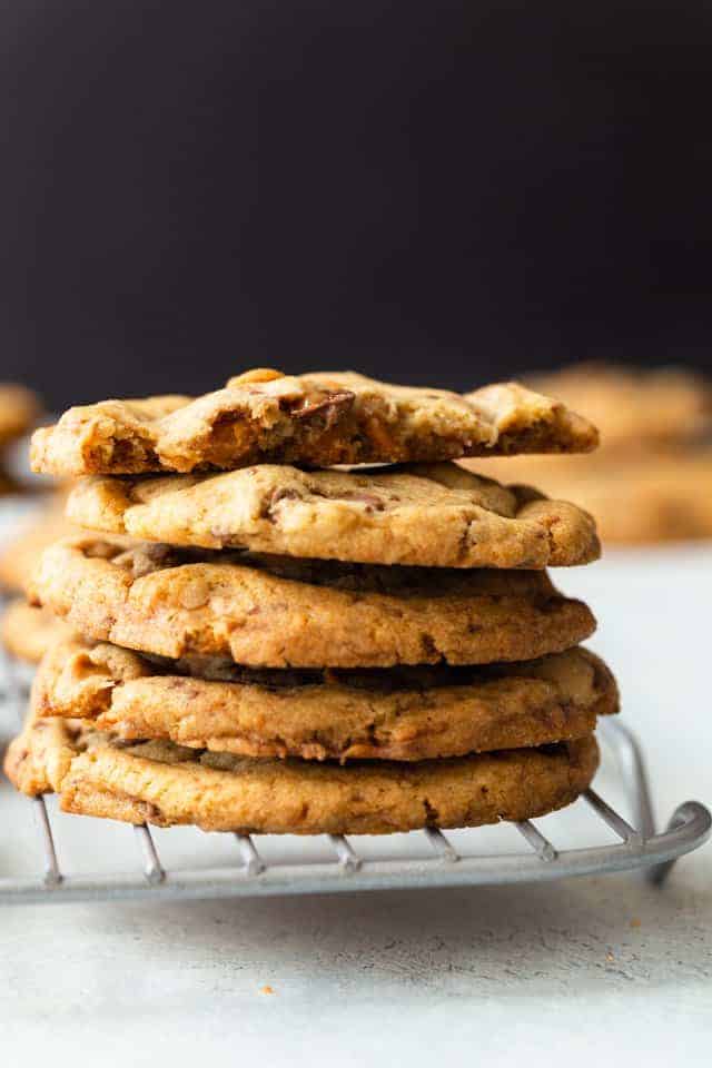 four and a half butterscotch toffee cookies stacked on a wire rack